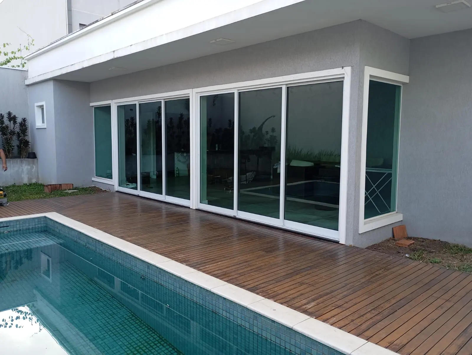 Portas de correr brancas de vidro com vista para piscina